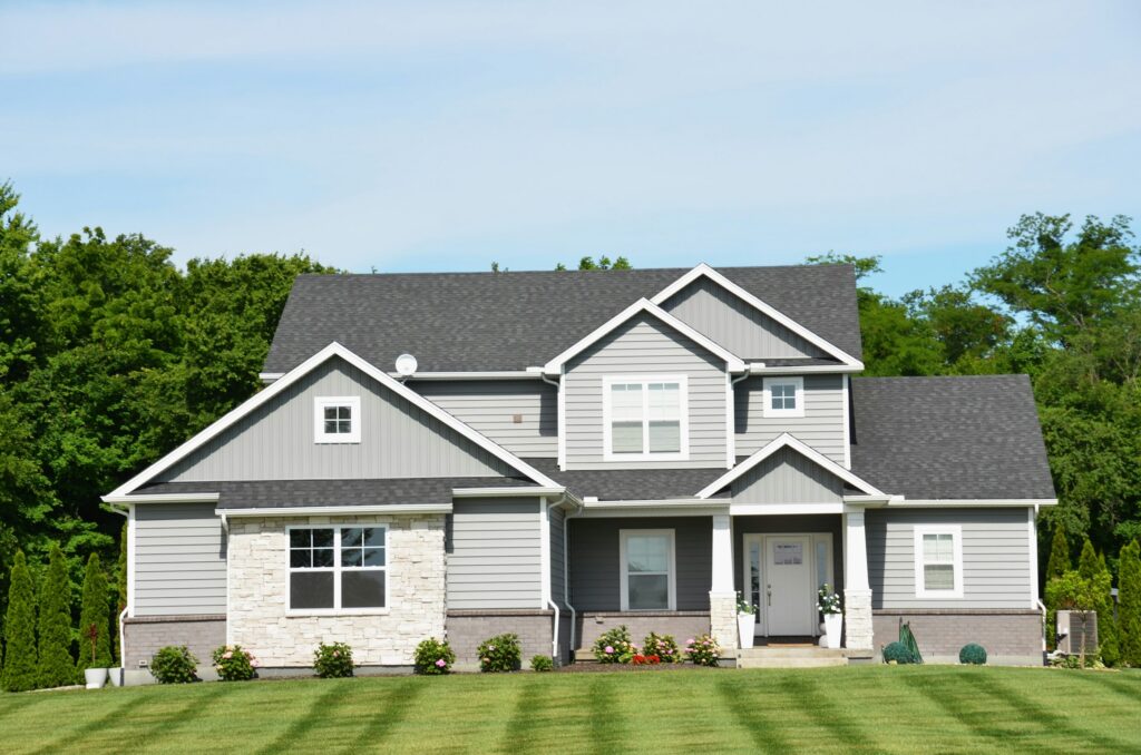 Gray two-story single-family home with a green lawn